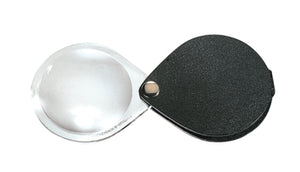 Circular magnifier inside clear oval setting, with attached fold-out black case