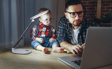 Load image into Gallery viewer, Father and toddler looking at a computer on a desk, with Daylight&#39;s Foldi Go. 

